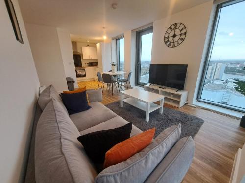 a living room with a couch and a tv at Media City Apartment Manchester in Manchester