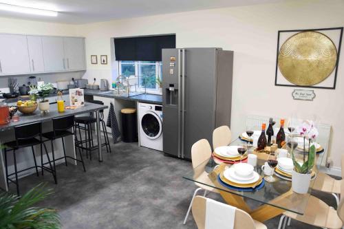 a kitchen and living room with a table and a refrigerator at Abington Villa Sleeps, Northampton Centre, 15 Games & Cinema Room in Spinney Hill