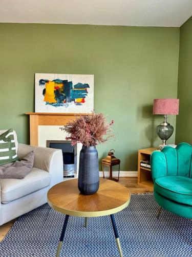 a living room with a vase on a coffee table at Two bedroom maisonette in the heart of the West End in Glasgow