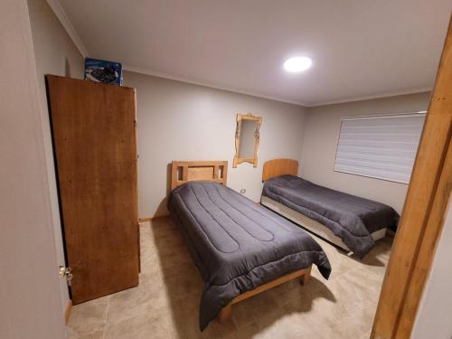 a bedroom with two beds and a door in it at Estancia Don Beto in Pan de Azúcar