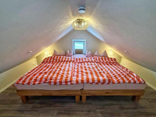 ein Schlafzimmer mit einem großen Bett im Dachgeschoss in der Unterkunft Ferienhaus Büdnerstube gratis Schwimmbadnutzung im AHOI Sellin in Middelhagen