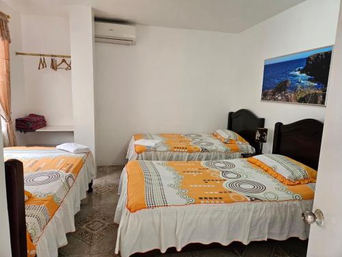 a room with two beds in a room at Hostal Cerro Azul in Puerto Villamil
