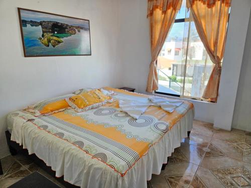 a bed in a room with a large window at Hostal Cerro Azul in Puerto Villamil
