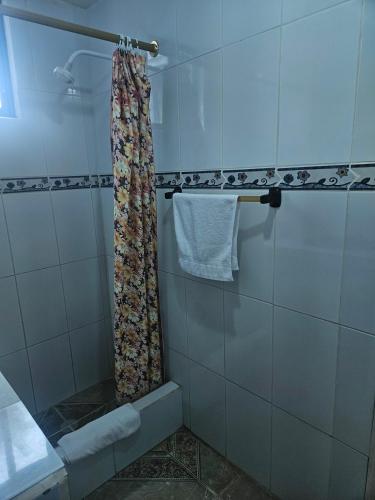 a shower with a floral shower curtain in a bathroom at Hostal Cerro Azul in Puerto Villamil