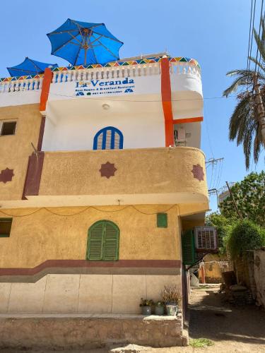 a building with green windows and a blue umbrella at La Veranda 陽台 in Aswan