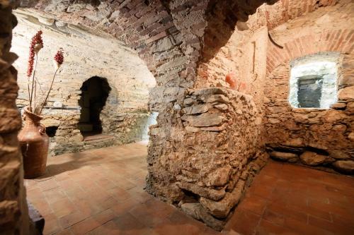 a room with a stone wall and a vase with flowers at Il Mulino di Nonna Sà - Prestige Private Villa in Pietrasanta