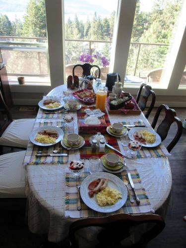 a table with plates of breakfast food on it at Okanagan Lake Sunrise BB in Vernon