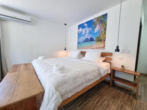 a bedroom with a bed with a painting on the wall at Pinilla Highlands Incredible mountain views in Tamarindo