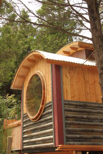 a tree house with a round window on it at La Casita del Tren - Tiny House in San Carlos de Bariloche