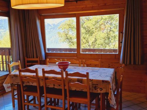 une salle à manger avec une table et des chaises et deux fenêtres dans l'établissement Chalet à Montalbert: 3 Chambres, Mezzanine, Cheminée, Cuisine Équipée, Parking - FR-1-755-7, à Aime La Plagne