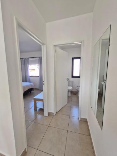 a hallway with a room with a bed and a mirror at Apart Origenes in Villa Regina