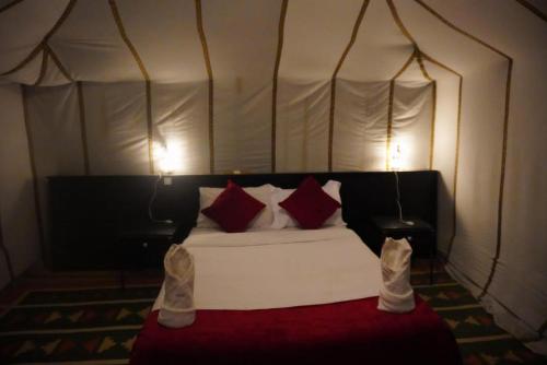 a bedroom with a bed in a tent at Aaladdin luxury camp in Merzouga
