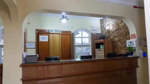 a court room with a counter and a mirror at Canoas Hotel Castel in Canoas