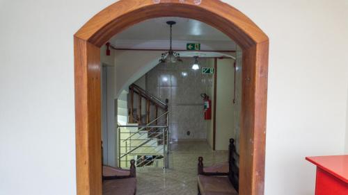 an archway leading into a hallway with a staircase at Canoas Hotel Castel in Canoas