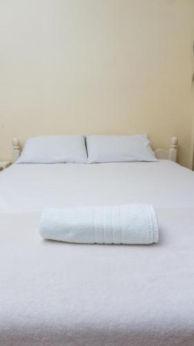 a white bed with white sheets and pillows at Canoas Hotel Castel in Canoas