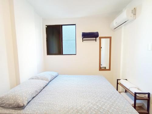 Una habitación blanca con una cama y una ventana en Intermares, Apartamento Automatizado e Inteligente - Piscina, Elevador, Garagem - Conforto, Paz e Sossego, excelente para descansar, trabalhar ou estudar, en Cabedelo
