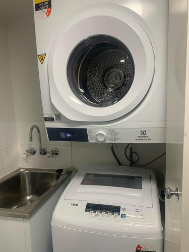 a washing machine in a kitchen with a sink at Fairways Golf & Beach Retreat Bribie Island in Woorim