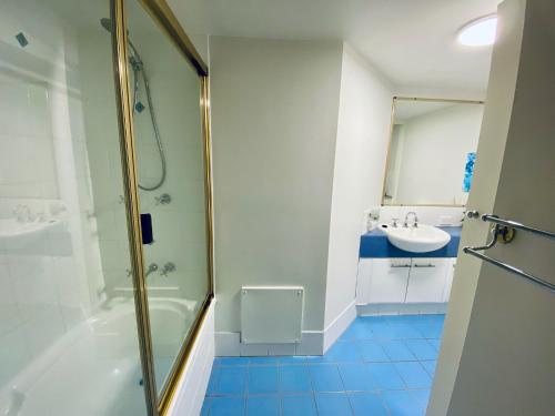 a bathroom with a shower and a sink at Fairways Golf & Beach Retreat Bribie Island in Woorim