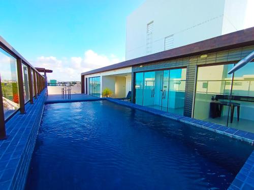 una piscina frente a un edificio en Intermares, Apartamento Automatizado e Inteligente - Piscina, Elevador, Garagem - Conforto, Paz e Sossego, excelente para descansar, trabalhar ou estudar, en Cabedelo