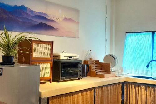a kitchen with a microwave on a counter with a window at The Town House in Pai