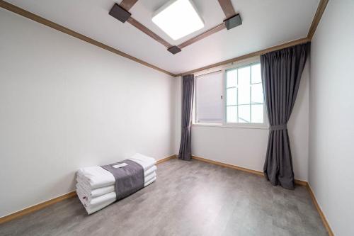 an empty room with a bed and a window at Sokcho Ritz Hotel in Sokcho