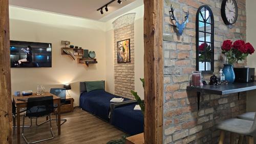 a living room with a couch and a brick wall at Magiczne Mieszkanko in Piła