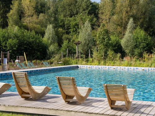 three chairs sitting next to a swimming pool at Charming Antoing Bungalow in Antoing