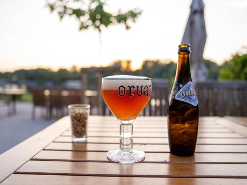 a glass of beer and a bottle on a table at Charming Antoing Bungalow in Antoing
