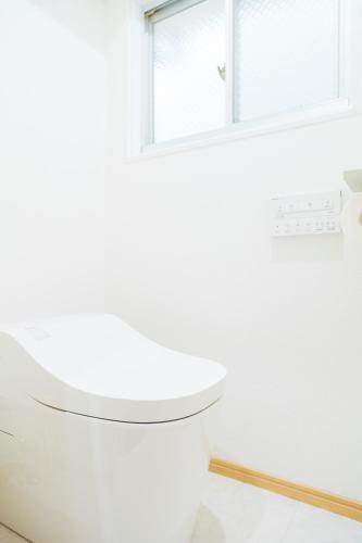 a white toilet in a bathroom with a window at 貸切戸建て Private House Sleep Man in Kagoshima