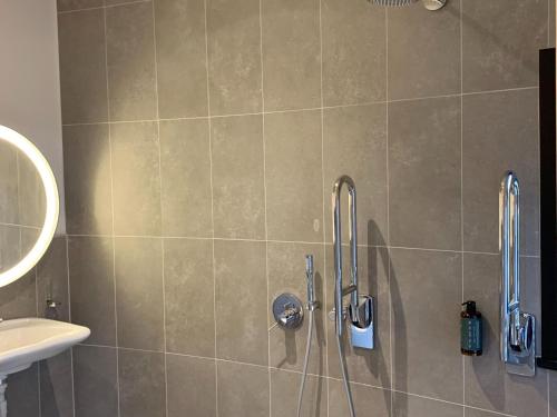 y baño con ducha y cabezal de ducha. en Peaceful Antoing Bungalow, en Antoing