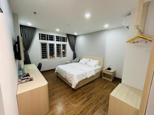 a bedroom with a white bed and a window at HAVI hotel in Ho Chi Minh City