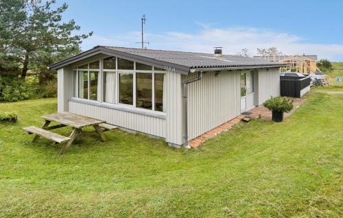 a small shed with a picnic table in the grass at 2 Bedroom Stunning Home In Rømø in Lakolk