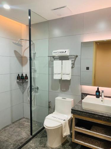 a bathroom with a toilet and a sink and a shower at Fan's Hotel Palo in Tacloban