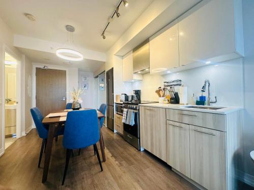 a kitchen with a wooden table and blue chairs at RivetStays - The Jarvis in Toronto
