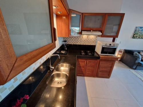 una piccola cucina con lavello e fornello di Apartamento tranquilo elegante espaçoso a Porto Seguro