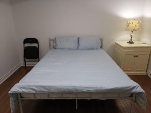 a bed in a room with a white mattress at Cozy Private Rooms in Basement in Richmond Hill