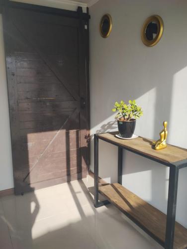 a room with a door and a table with a plant on it at Glamping Domos Lago Rapel in El Estero