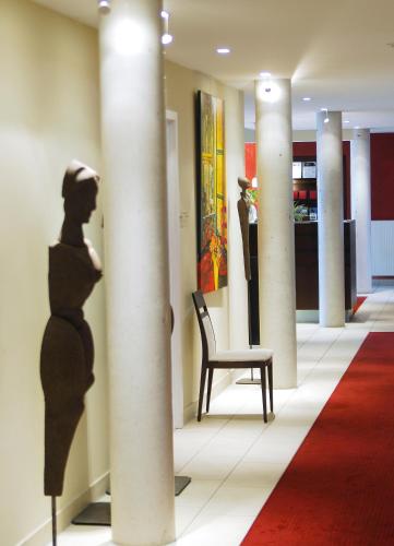 a pillar in a hallway with a chair and a column at Hotel Schepers in Gronau