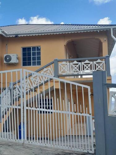 a house with a white railing and a balcony at Windsor Apartment in Kingstown