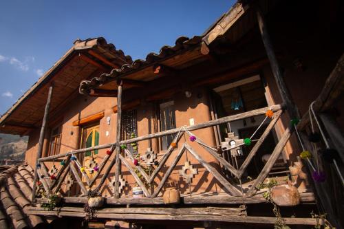 a wooden balcony of a house with a fence at Sonidos del Ande Wasi in Pisac