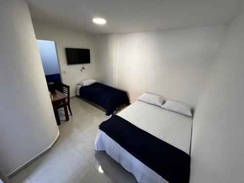 Un pequeño dormitorio con una cama y un televisor. en Flat completo para até 4 pessoas no Vidigal - RJ, en Río de Janeiro
