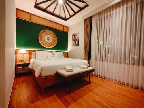 a bedroom with a bed and a table and a window at Rabasta Enjoy Kuta in Denpasar