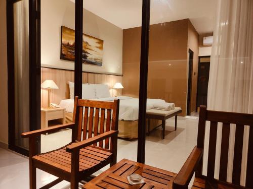 a bedroom with a bed and a chair and a table at Rabasta Enjoy Kuta in Denpasar
