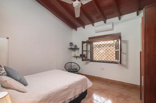 a bedroom with a bed and a window at La Luqueña House in Luque