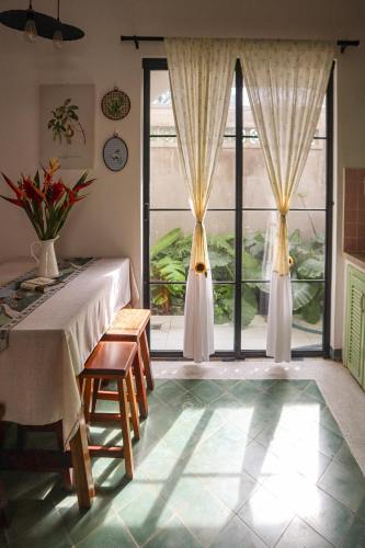a dining room with a table and a large window at DƯỚI TÁN CÂY homestay in Tây Ninh