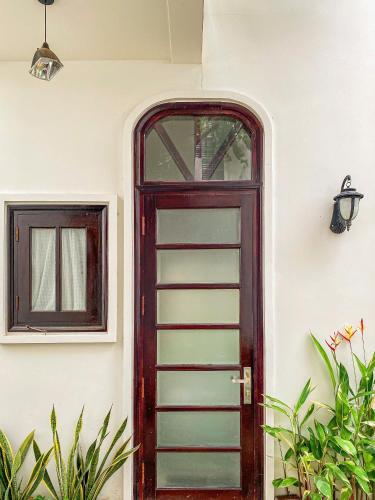 a door to a house with a window and plants at DƯỚI TÁN CÂY homestay in Tây Ninh
