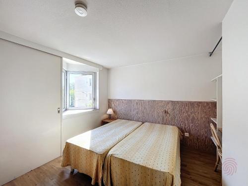 une chambre avec un lit et une fenêtre dans l'établissement Studio avec terrasse, proche thermes et centre, animaux acceptés, wifi inclus, Lamalou-les-Bains - FR-1-451-66, à Lamalou-les-Bains