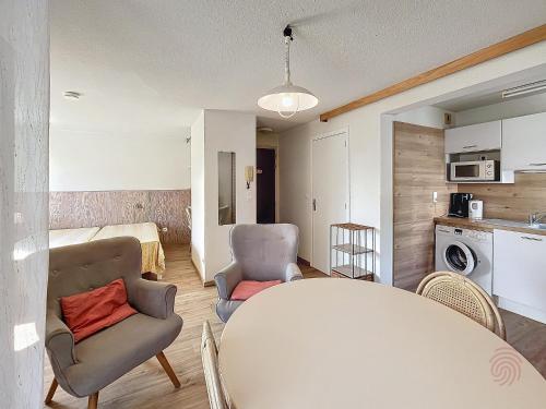 une cuisine et un salon avec une table et des chaises dans l'établissement Studio avec terrasse, proche thermes et centre, animaux acceptés, wifi inclus, Lamalou-les-Bains - FR-1-451-66, à Lamalou-les-Bains