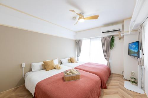 a bedroom with two beds and a tv at Beige2nd in Tokyo