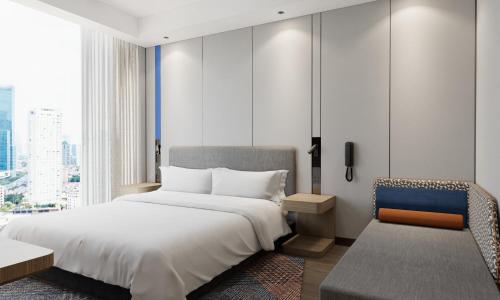 a bedroom with a large white bed and a chair at Holiday Inn Express Xi'an Daxing by IHG in Xi'an